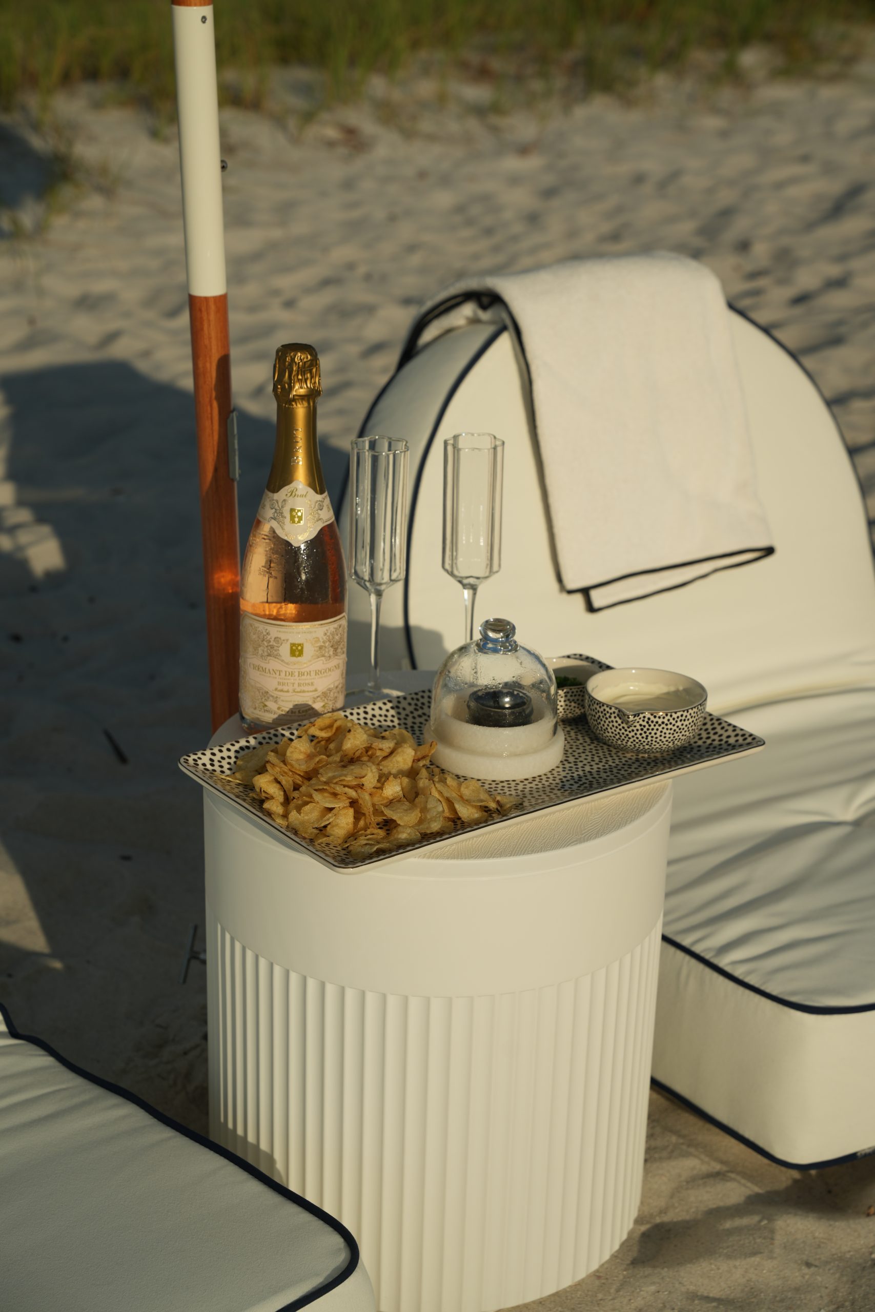 Styled umbrella and seating arranged for a group on the beach