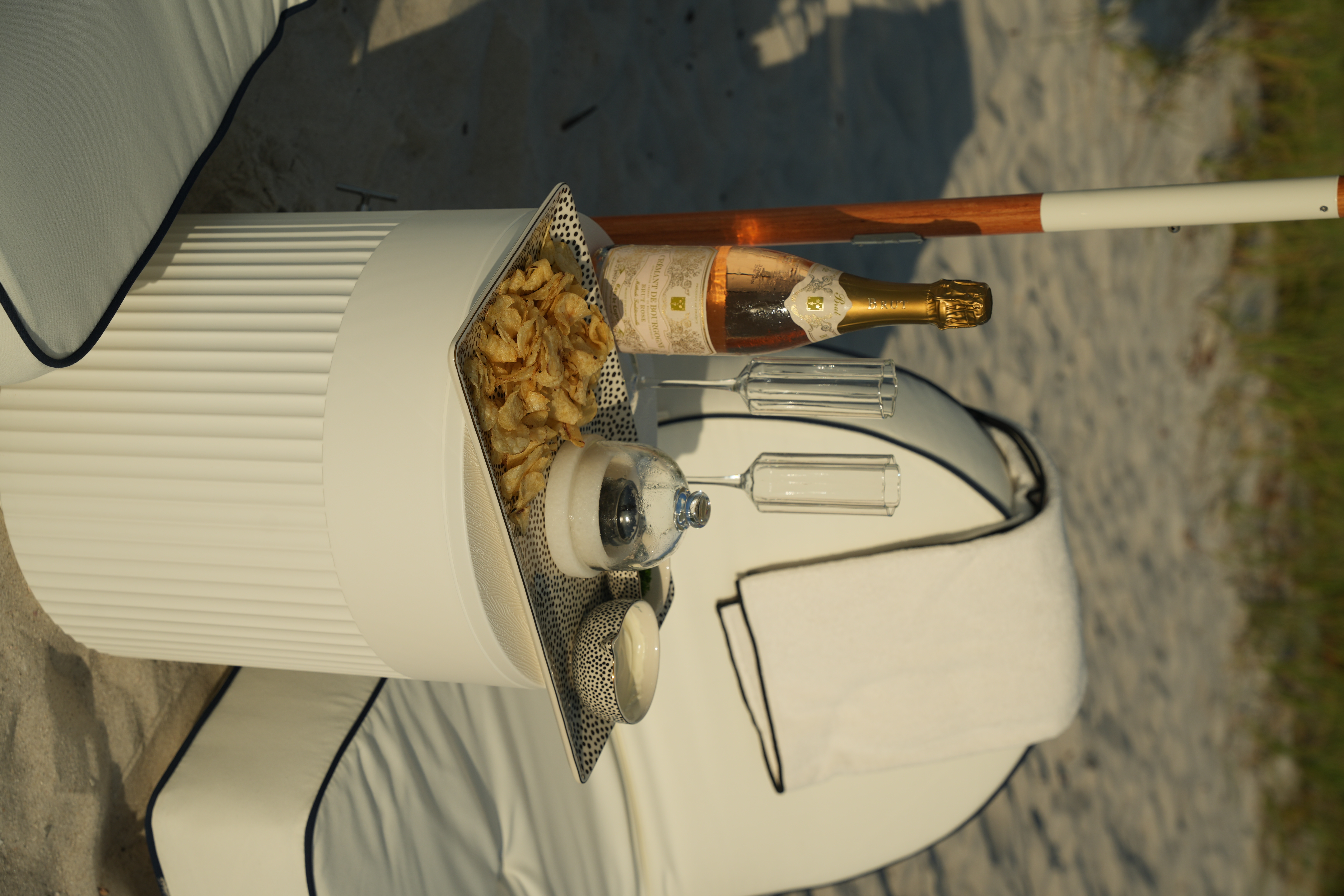 Chilled ros&eacute;, champagne flutes, and a styled tray at golden hour